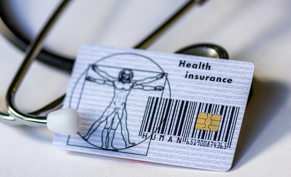 health insurance ID lying on top of stethoscope