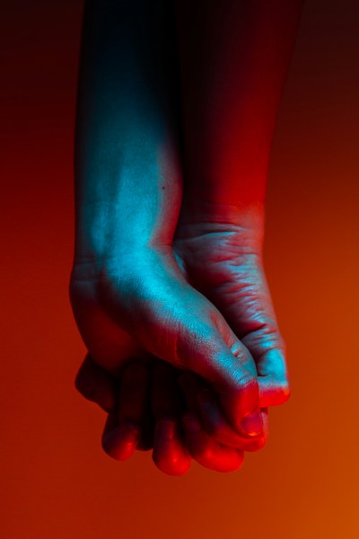Two hands clenched in red lighting