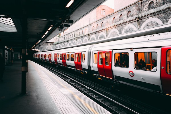 red and white train near a station and building