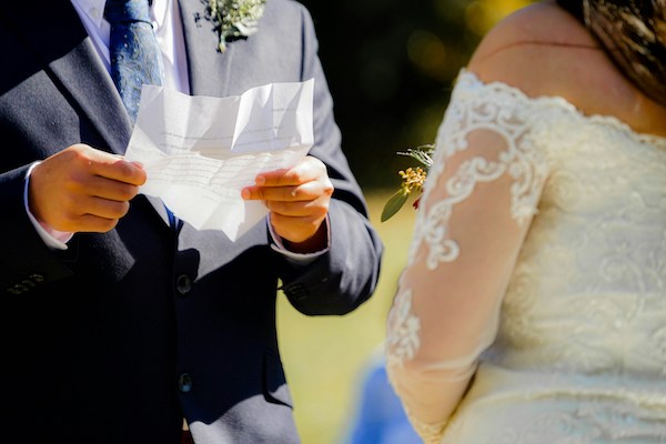 a bride and groom reading vows